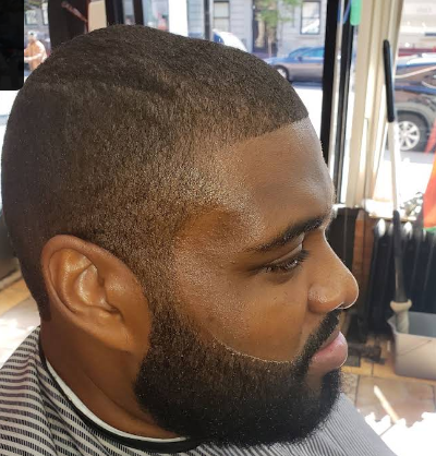 Full beard sculpt paired with a low fade
